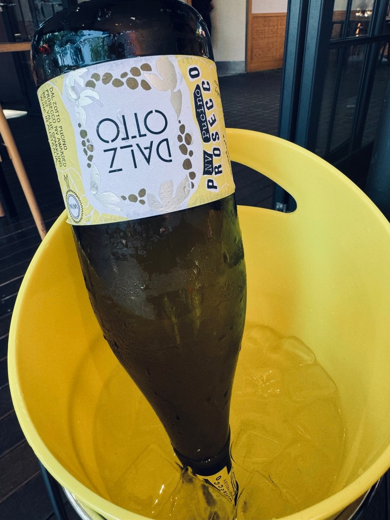 Upside down prosecco bottle in yellow ice bucket